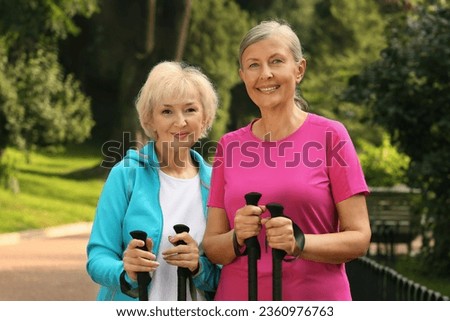 Senior women with Nordic walking poles outdoors Royalty-Free Stock Photo #2360976763
