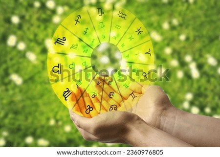 Astrology. Woman holding zodiac wheel on bright background, closeup