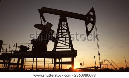 oil production. silhouette oil and gas production rig at sunset glare. oilfield business lifestyle extraction concept. oil extraction pump. Oil pump rig