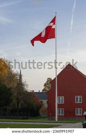 danish flag is waiving in the evening sky