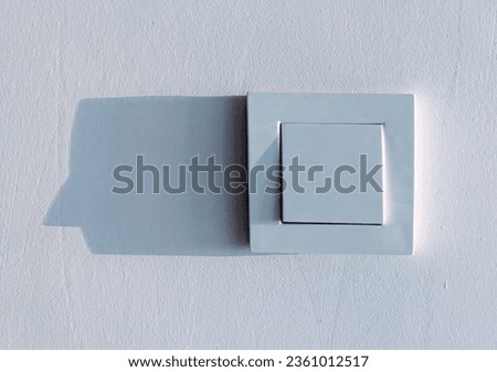 Wall switch and its shadow on a white background