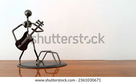 Showpiece of metal presentiing a man holding guitar. black steel symbolic piece of music colver. Cover pic for any musical event or concert. Background for music, guitar, guitarist or any art form