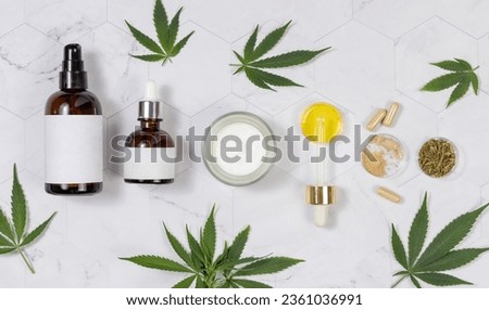 Cosmetic bottles, jar, pipette with CBD oil, capsules with hemp powder and infusion tea near green cannabis leaves on a marble table top view. Organic skincare and healthcare products. CBD Cosmetic 

 Royalty-Free Stock Photo #2361036991