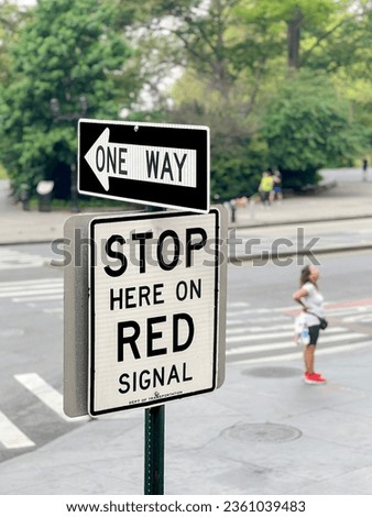 one way, stop and one way direction traffic sign at corner and pedestrian crossing on road in New York, United States of America. traffic sign in English at street in the city. pedestrian crossing