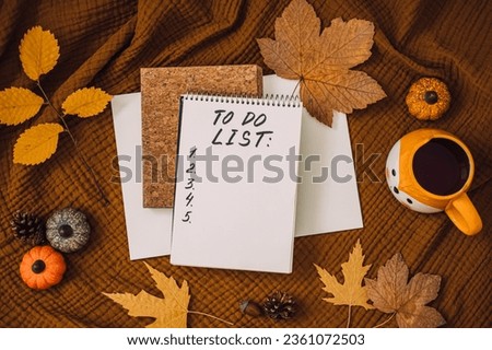 Autumn To Do List in open notepad with fall leaves at home. Fall Bucket List Autumn Activities and Fun Things to Do.