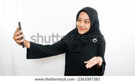 Cheerful young Asian woman taking selfie, look smartphone front camera isolated over white background