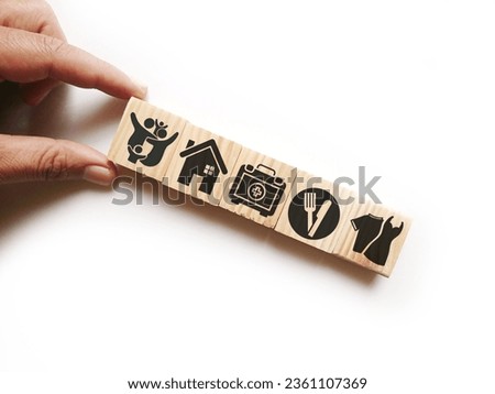wooden cube with icons of food, Clothing, housing, medical bag, four basic human needs concepts. The Four Basic Material Needs of the Human Being. Royalty-Free Stock Photo #2361107369