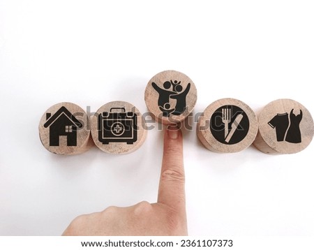 wooden cube with icons of food, Clothing, housing, medical bag, four basic human needs concepts. The Four Basic Material Needs of the Human Being. Royalty-Free Stock Photo #2361107373