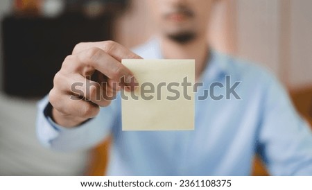 Portrait of Businessman or freelancer put a yellow sticky note to glass. Concept of inspiration, ideas, planning work and explaining background. Creativity and brainstorming reminder meeting.