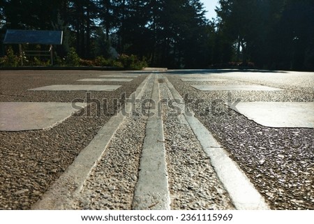 Guide textured lines to suggest the correct direction of movement for visually impaired, blind people in wheelchairs or with a pole when crossing highways at pedestrian crossing points.