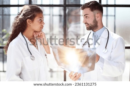 Two busy doctors working with papers and xray images