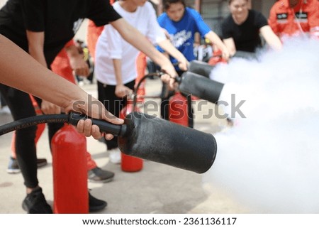 Employees firefighting training, Concept Employees hand using fire extinguisher fighting fire closeup Royalty-Free Stock Photo #2361136117