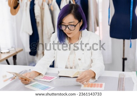 young woman fashion stylist designer select color from pantone chart, professional dressmaker design clothing new collection, female freelance tailor working at home dress shop small business owner Royalty-Free Stock Photo #2361143733