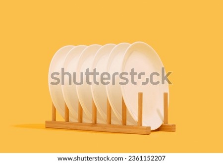 Elegant dinnerware in the wooden dish rack. Clean empty plates. Royalty-Free Stock Photo #2361152207
