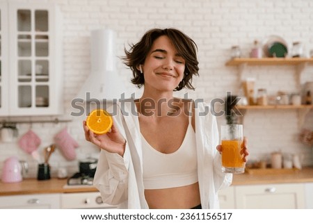young pretty woman cooking at home, morning kitchen, healthy food, cutting fruits oranges, making orange juice Royalty-Free Stock Photo #2361156517