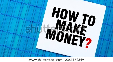 blank note pad with HOW TO MAKE MONEY text on blue wooden background