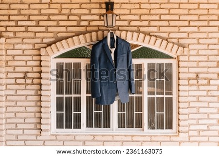 groom's suit hanging in a window to buy a harmonic photograph