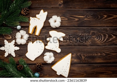 Homemade baked white Christmas cookies with fir tree branches. New Year background.