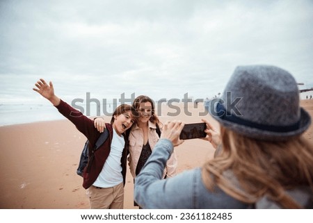 Young family taking pictures of each other while on vacation on a beach