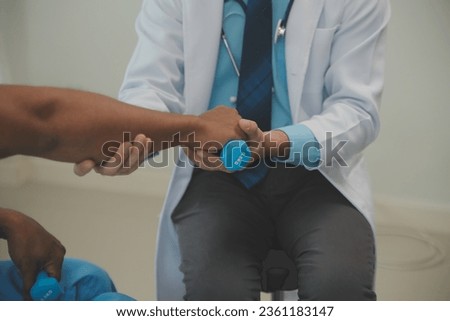 Physiotherapist man giving exercise with dumbbell treatment About Arm and Shoulder of athlete male patient Physical therapy concept Royalty-Free Stock Photo #2361183147