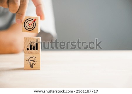 A businessman's hand skillfully stacks wood blocks, depicting a strategic business plan and Action plan. This concept represents business development and growth in the professional realm.