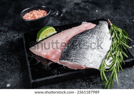 Uncooked Raw Dorado Sea bream fish fillets. Black background. Top view. Royalty-Free Stock Photo #2361187989