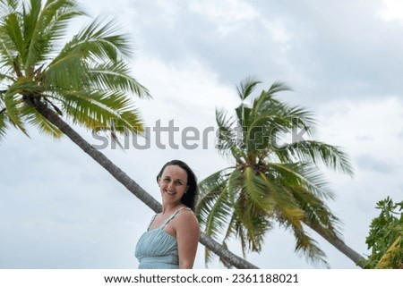 A portrait of young pretty woman near palms in windy weather on Maldives 