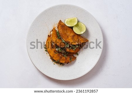 Top view of 3 quesabirria tacos on a white plate