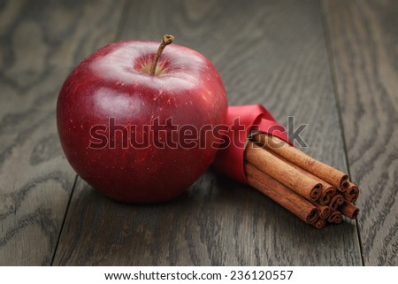 red ripe apple and cinnamon, on old oak table