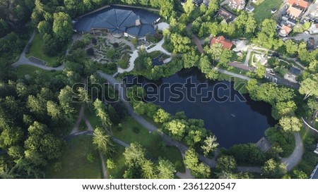 Aerial shot of the pond in the Kurpark surronded by trees in Braunlage, Lower Saxony, Germany captured with a drone on a sunny day.