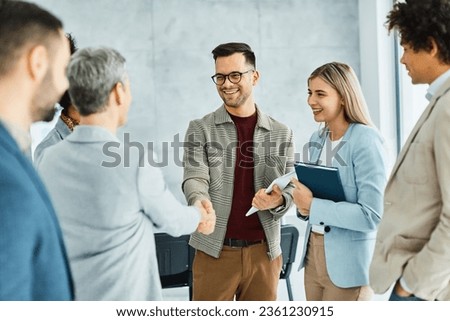 Group of young business people having a meeting shaking hands handshake introducing each other in the office. Teamwork and success concept Royalty-Free Stock Photo #2361230915