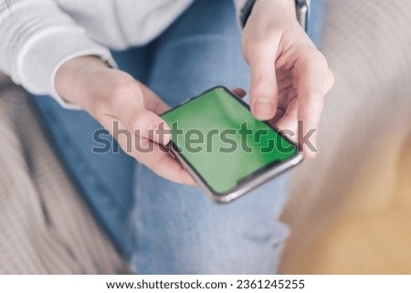 Close-up of woman with chroma key phone sitting on a couch