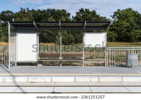 Bus station billboard with blank copy space screen for business advertising text or promotional content on bus shelters. Public transport stop with protective glass and white lightbox