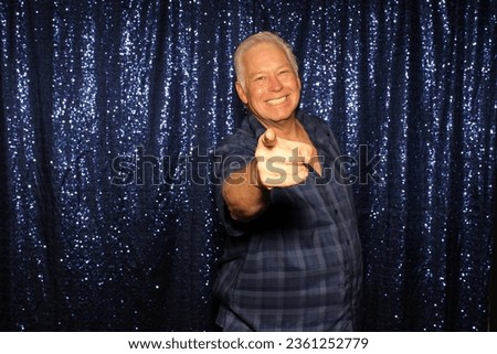 Photo Booth. A man smiles and poses for his pictures to be taken while in a Photo Booth at a Wedding. Photo Booths are popular at Weddings, Birthdays and all events both Public and Private. Fun Times.