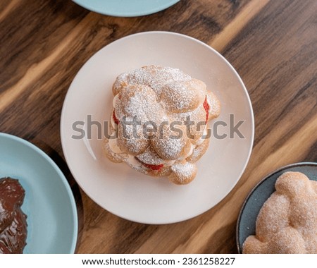 Delicious traditional mexican pan de muerto, filled with delicious cream, with red fruits inside, strawberries and blackberries. Royalty-Free Stock Photo #2361258227