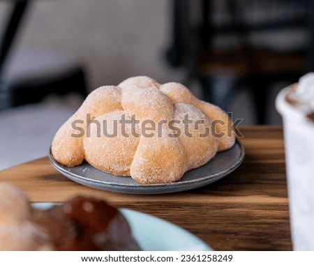 Delicious traditional mexican pan de muerto, with cajeta on top, sugar, inside a coffee, for the day of the dead, mexican culture. Royalty-Free Stock Photo #2361258249