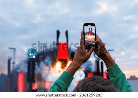 Crowd Enjoying a Summer Outdoor Music Festival and Taking Pictures via Smartphones