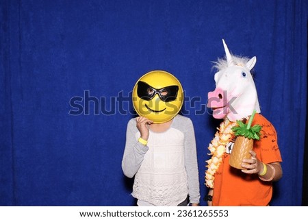 Photo Booth. Two people wear Animal Head Masks and pose for pictures while in a Photo Booth. Photo Booths are popular at all parties and events. Everyone loves Photo Booth Pictures. Horsing around. 