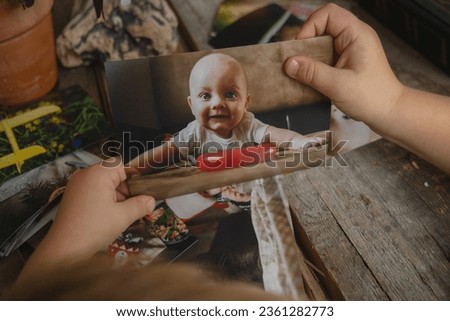 Photo printing concept. Toddler hands hold printed photo.