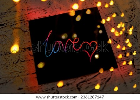 Note I love you for Valentines Day. Art scratch paper for message. String lights, shiny