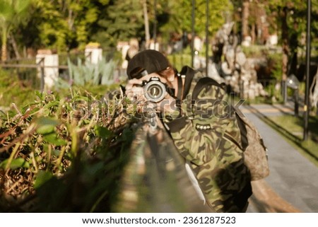 Traveling photographer in camouflage looks for interesting places to take photos.