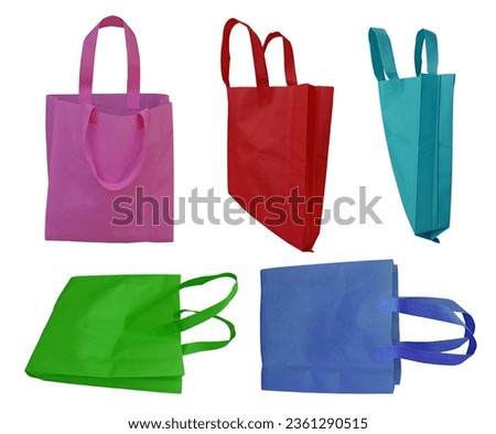 five pieces of non-woven fabric tote bags in purple, red, turquoise, green and blue isolated on white background. sets or collections with various colors. eco-friendly polypropylene bags Royalty-Free Stock Photo #2361290515