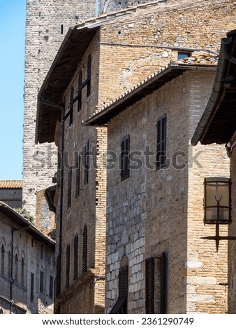 San Gimignano, Italy - June 29 2023: Old buildings in San Gimignano. San Gimignano is a small walled medieval hill town in the province of Siena, Tuscany.