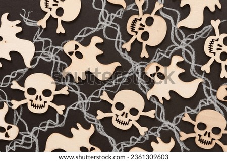 cut wooden halloween embellishments on black paper with wavy white lines