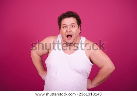 Drunk fat man posing on a pink background. Alcohol and a healthy lifestyle.