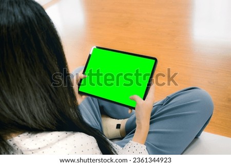Woman using and holding blank screen tablet green background for text message, copy scpace adverting. Technology and new normal lifestyle working from home concept.