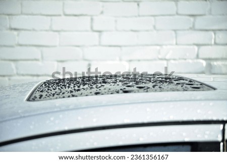 The roof of the car from raindrops. After washing the car.Close-up of raindrops on the roof of the car. the surface of the car. for a design background.Cloudy weather concept