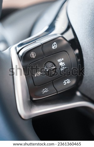 Driving assistant fucntion buttons on multi-function steering wheel of the luxury car. Vehicle equipment part and object photo. Royalty-Free Stock Photo #2361360465