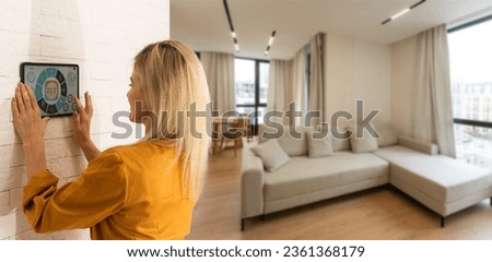 Woman pressing on smart home automation panel monitor Royalty-Free Stock Photo #2361368179