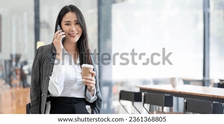 happy businesswoman sitting at office and talking with somebody on her mobile phone while working from home.  Royalty-Free Stock Photo #2361368805